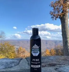 A bottle of massage oil sitting on top of a mountain.